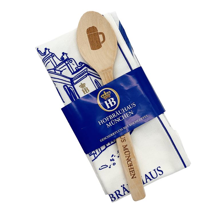 HB-Geschirrhandtuch mit blauem Hofbräuhaus-Motiv, kombiniert mit einem Holzkochlöffel mit Bierkrug-Gravur, verpackt im Set mit Hofbräuhaus München Banderole.